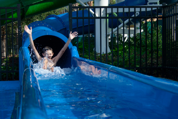 Boy exiting fast slide with a splash